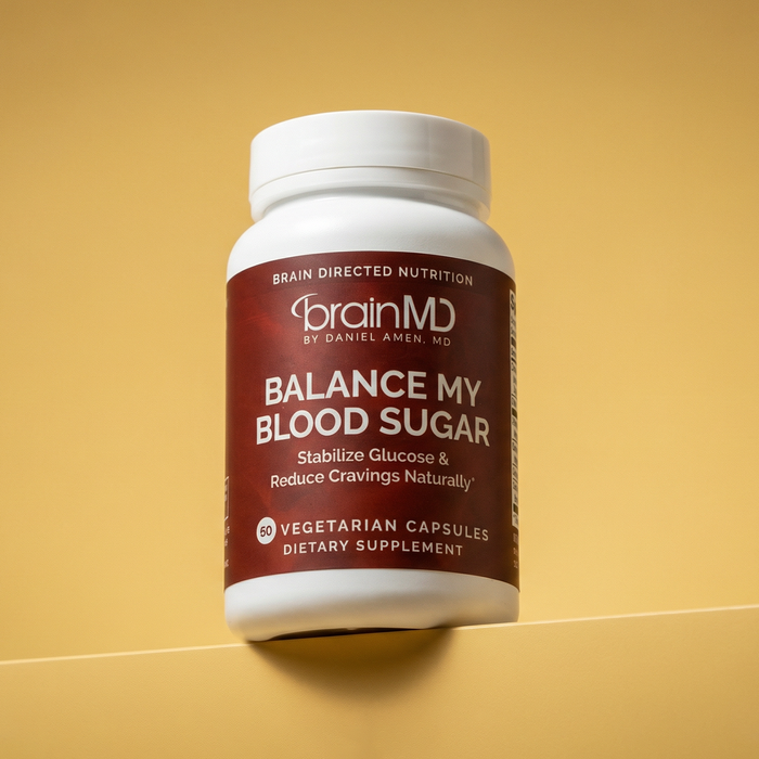 Dark red supplement bottle against a yellow background.