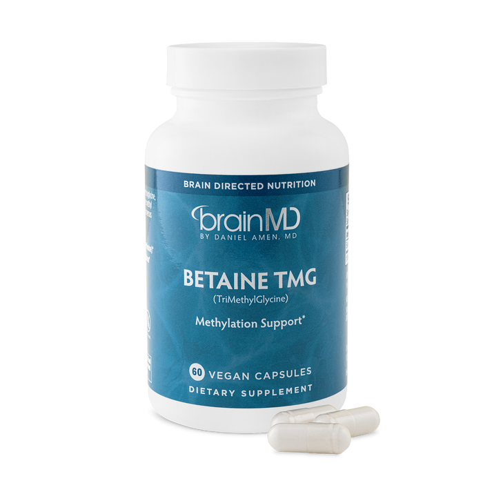 BrainMD Betaine TMG: blue supplement bottle with capsules at the base against a transparent background