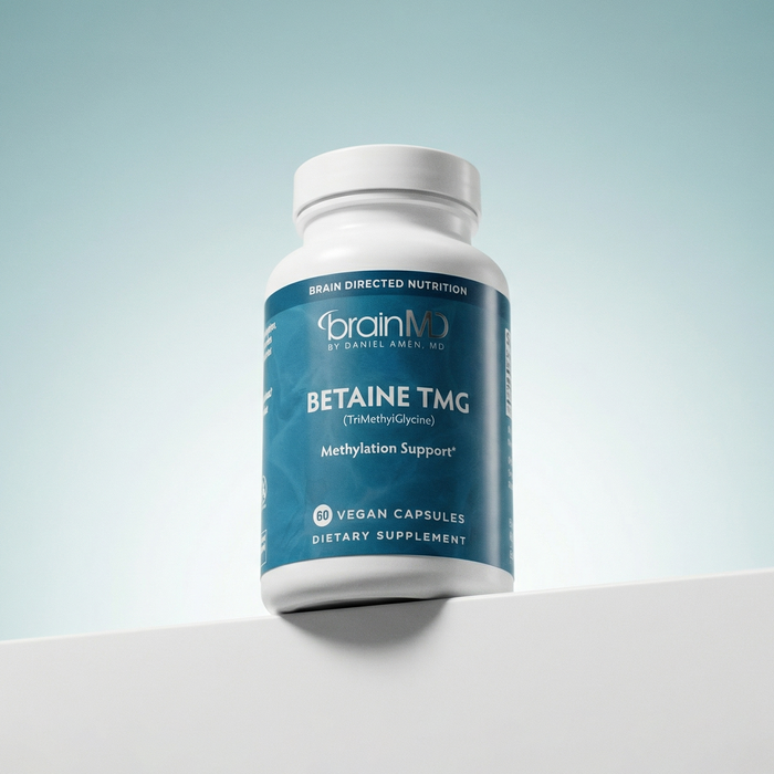 Supplement bottle labeled 'BETAINE TMG' by brainMD on a light gray background