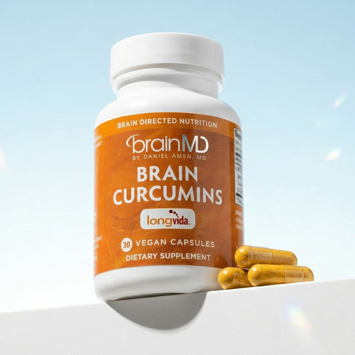 Supplement bottle labeled 'Brain Curcumins' by BrainMD on a light blue background
