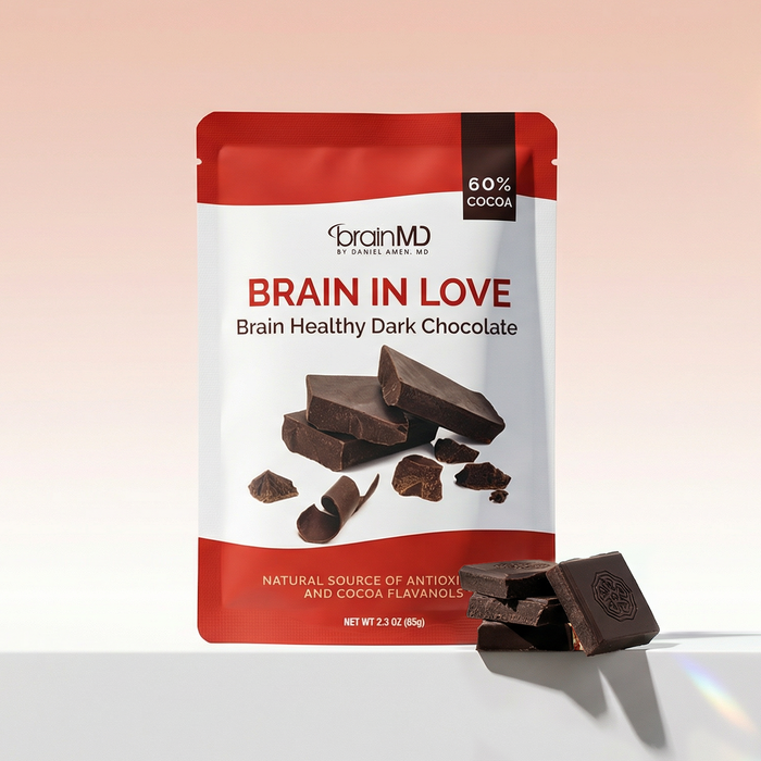 Red chocolate bar package with chocolate squares at the base against a light peach background.