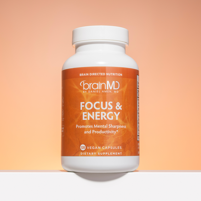 Orange supplement bottle against a cantaloupe-hued background.