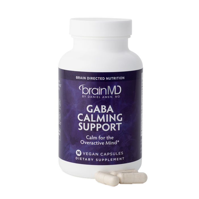 BrainMD GABA Calming Support: front of purple supplement bottle and capsules against a transparent background