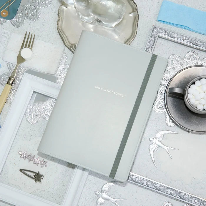 The closed cover on a laid table with silver cutlery, lace and a cup of coffee