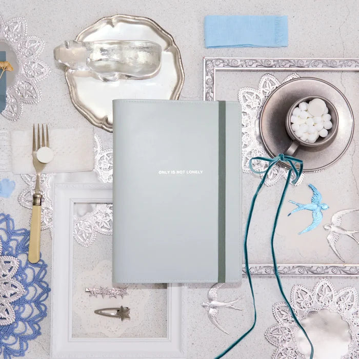The cover on the table with lace, blue flowers and a trailing blue ribbon