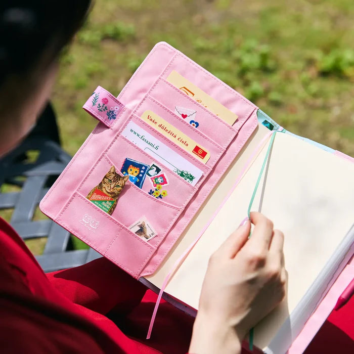 Hands holding the cover open, cards tucked into the pink inside pockets