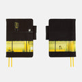 Hobonichi 2027 A6 Planner Cover (Akiko Miyakoshi - An Airport at Night): front and back of the cover, black above a lit night-airport scene, yellow ribbon bookmarks trailing