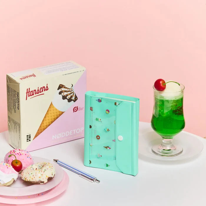 The closed cover on pink beside an ice-cream box and a tall cream soda