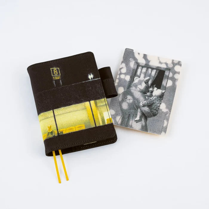 Two covered techo books with a monochrome pencil board from the series propped alongside