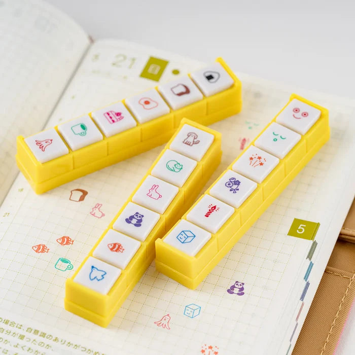 Kodomo no Kao x Hobonichi Pochitto6 Push-Button Stamp (Moomin): the yellow stamp bar with its six buttons, resting on a grid page already dotted with its marks