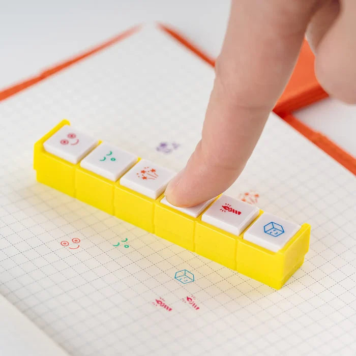A fingertip pressing one of the buttons down onto a grid page