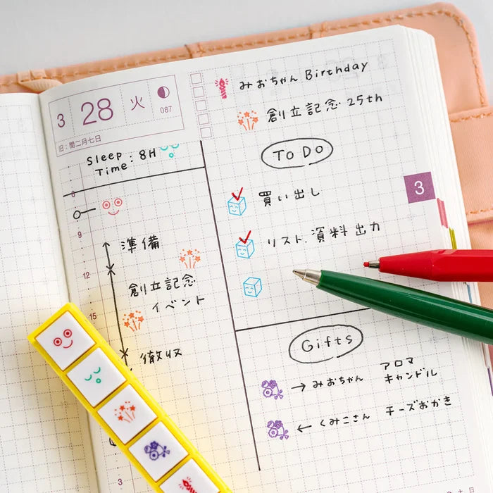 An open techo weekly page decorated with the stamps, a red pen resting alongside