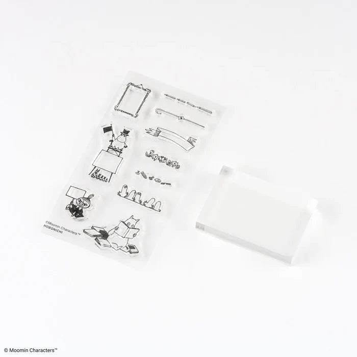 The sheet of frame designs laid beside the clear acrylic block