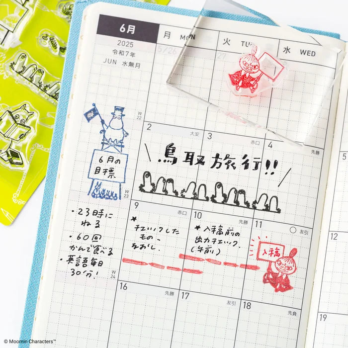A techo monthly page with a red stamped frame, a hand steadying the acrylic block