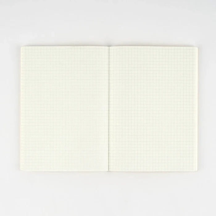The notebook opened flat, pale cream graph pages running across the spread