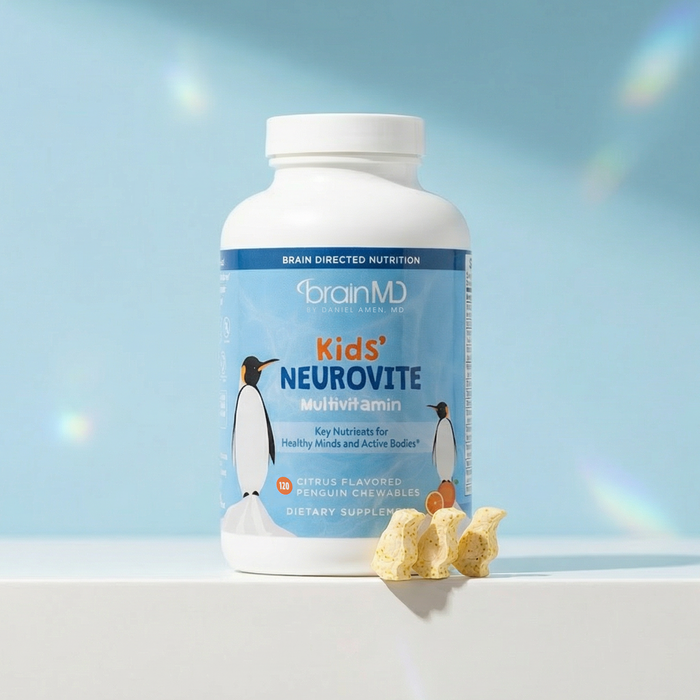 Light blue supplement bottle with penguin-shaped chewables at the base against a powder blue background.