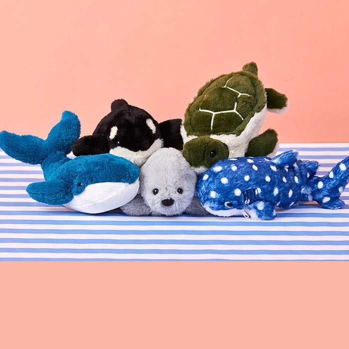 Assorted Pouzoo animal design cushion pouches including dolphin, turtle and seal on a pink and striped blue surface.