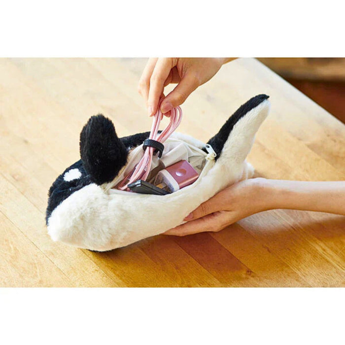 Hand opening a Pouzoo animal design cushion pouch with zip closure.