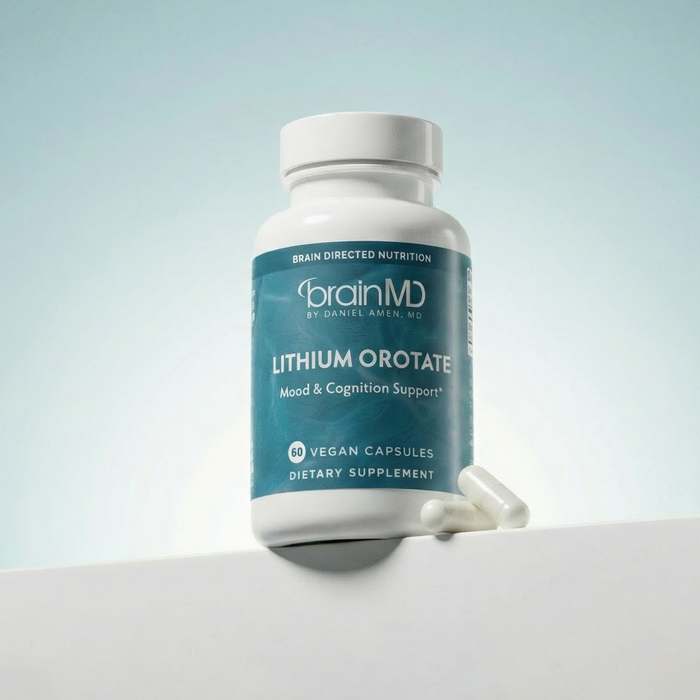 Light blue supplement bottle with white capsules at the base against a powder blue background.