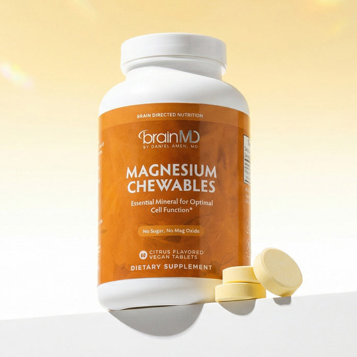 Orange supplement bottle with orange tablets at the base against a light orange background.