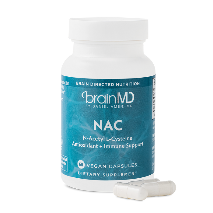 BrainMD NAC: image of blue supplement bottle and three white capsules at its base with transparent background