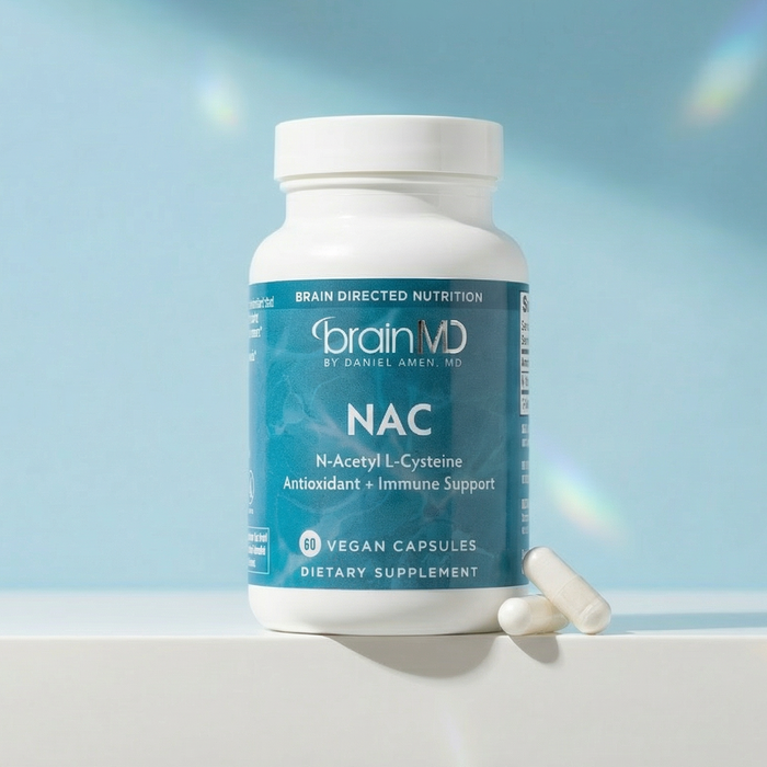 Light blue supplement bottle with white capsules at the base against a powder blue background.
