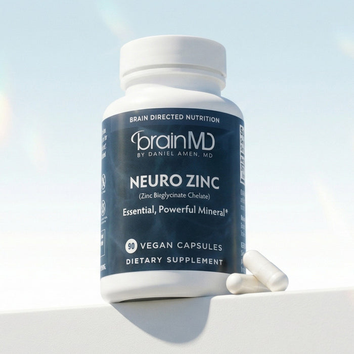 Blue supplement bottle with white capsules at the base against a light blue background.