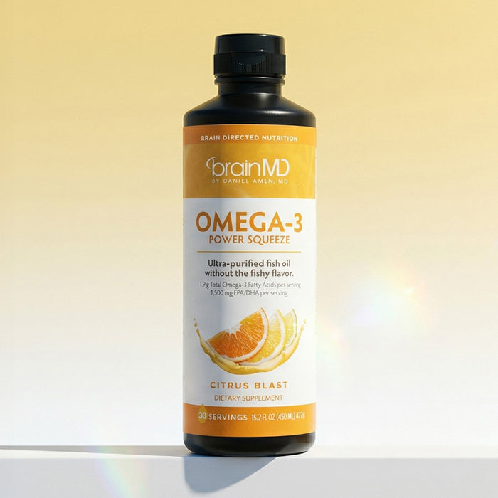 A tall, orange liquid supplement bottle against a light-yellow background.