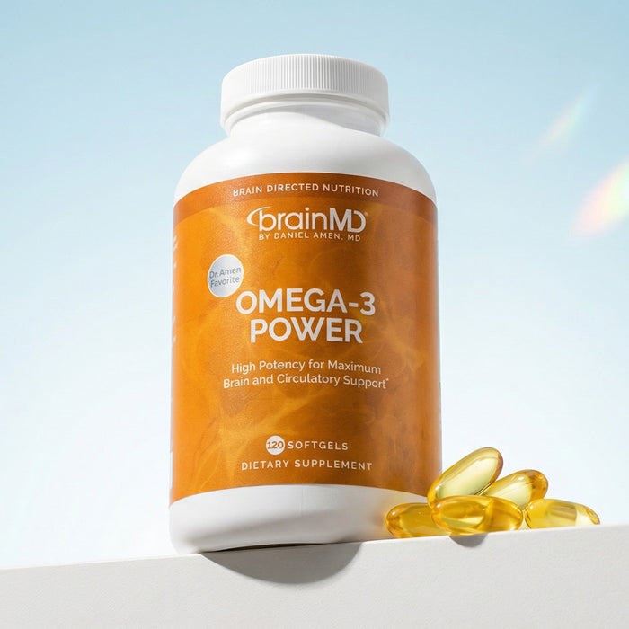 An orange supplement bottle with golden softgels at the base against a powder blue background.