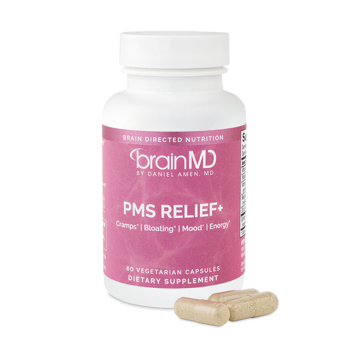 BrainMD PMS Relief+: pink supplement bottle with capsules against a transparent background