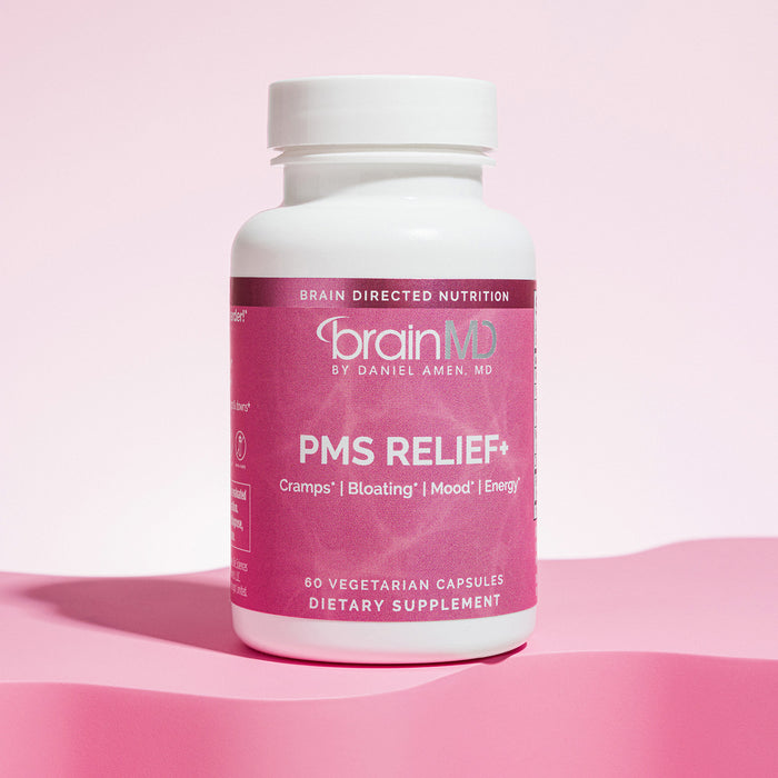 Pink supplement bottle against a light pink background.