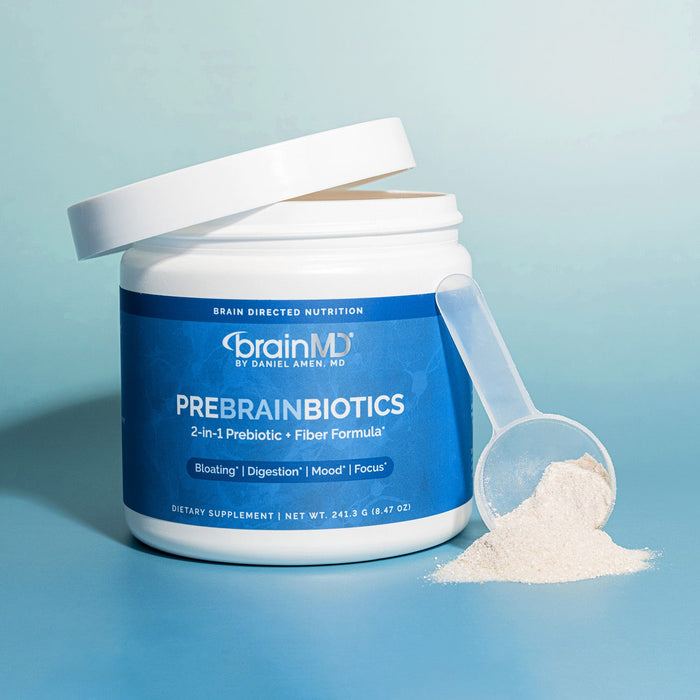 BrainMD PreBrainBiotics: blue supplement container with scoop of white powder against a light blue background