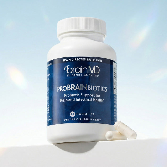 Blue supplement bottle with white capsules at the base against a light blue background.
