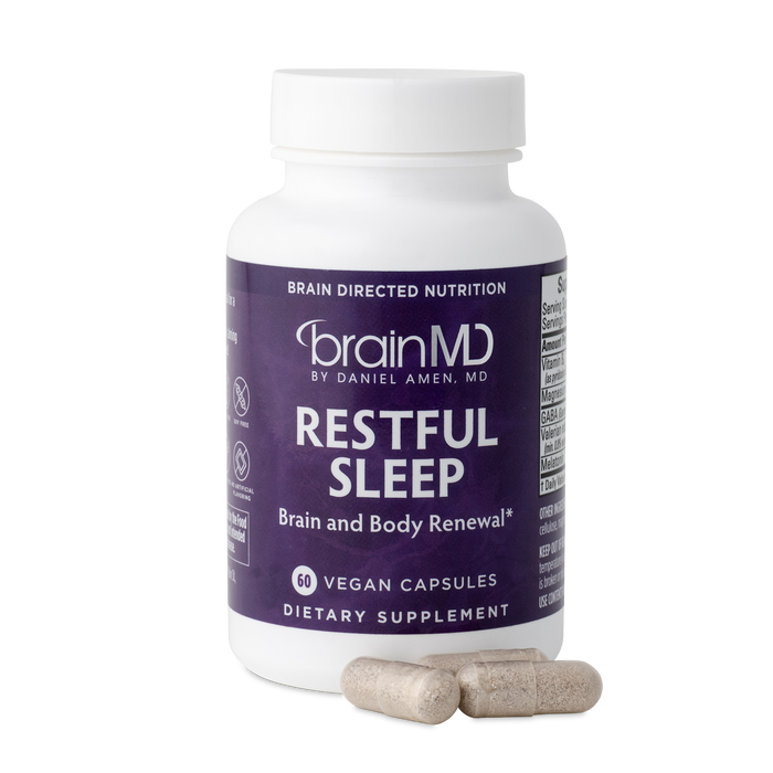 BrainMD Restful Sleep: purple supplement bottle with capsules against a transparent background