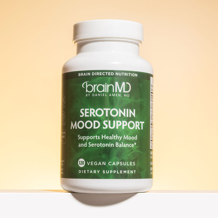 Green supplement bottle against a light yellow background.