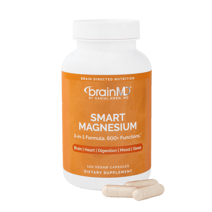 Orange supplement bottle with white capsules at the base against a transparent background.