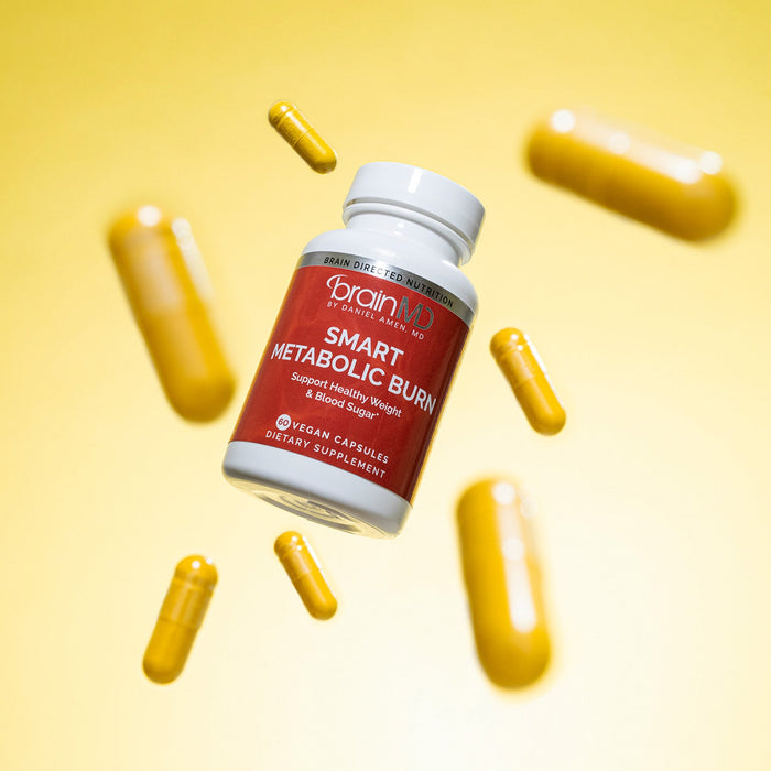 BrainMD Smart Metabolic Burn: red supplement bottle with capsules surrounding it against a yellow background