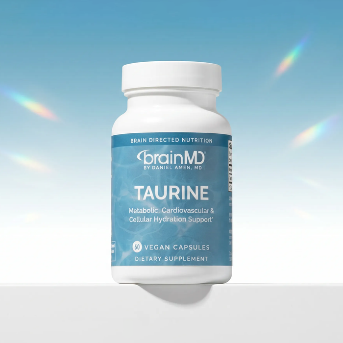 Supplement bottle labeled 'brainMD Taurine' on a gradient blue background