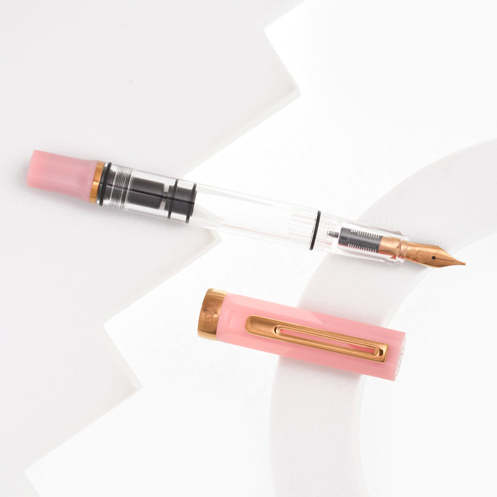 TWSBI ECO Pink Lemonade fountain pen uncapped, showing the bronze nib and pink faceted cap.