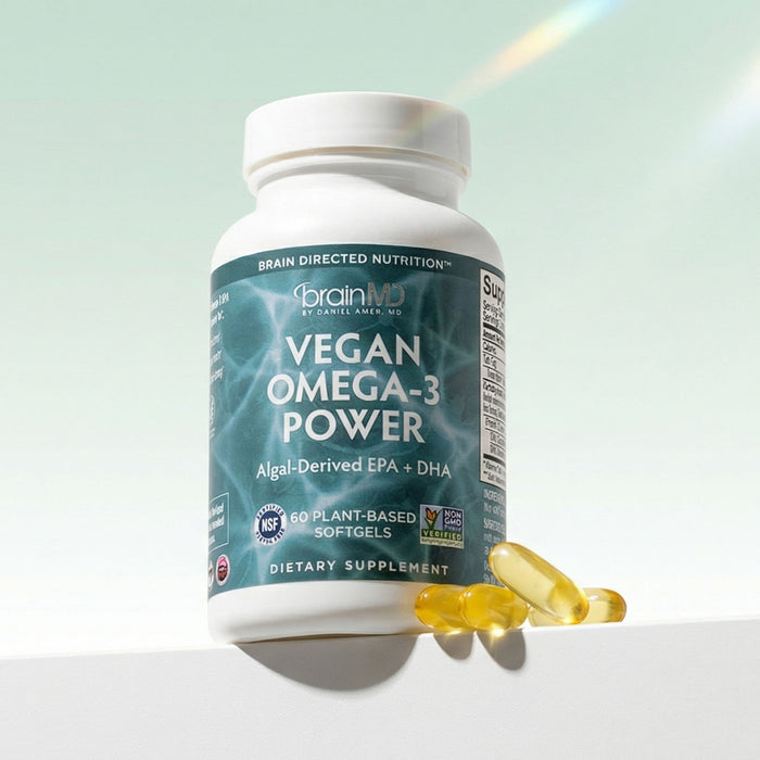 Green supplement bottle with golden gelcaps at the base against a mint green background.
