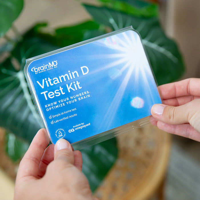 Hands holding the BrainMD Vitamin D Test Kit, a simple at-home vitamin D blood test with lab-verified results
