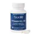 BrainMD Vitamin D3 + K2: image of blue supplement bottle and three off-white capsules at its base with transparent background