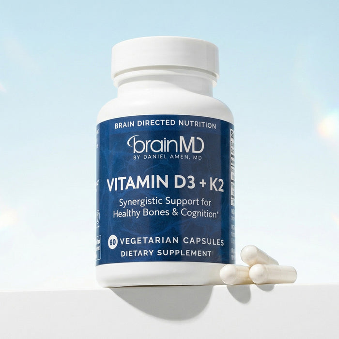 Dark blue supplement bottle with three white capsules against a powder blue background.